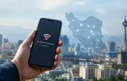 اختلال اینترنت در ایران؛ گوشی با پیام No Internet Connection روی پس‌زمینه تهران